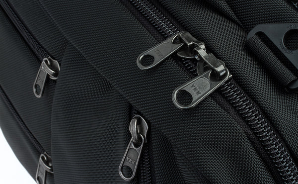 A close shot of the regular zippers of the front pockets and locking zippers on the main compartment of the Western Flyer.